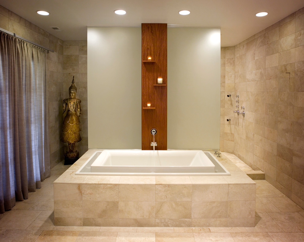 Inspiration pour une salle de bain minimaliste avec une baignoire posée et un mur en pierre.