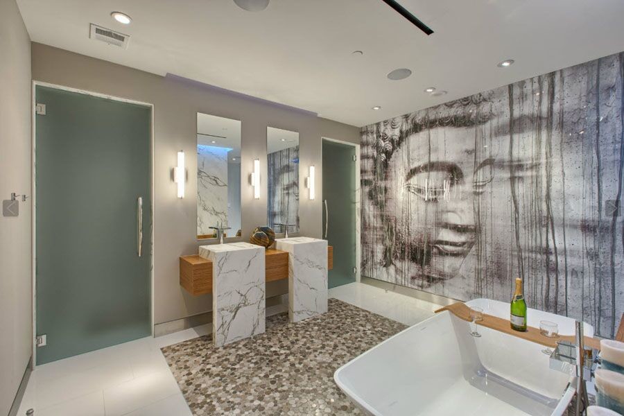Photo of a large contemporary ensuite wet room bathroom in Los Angeles with open cabinets, medium wood cabinets, a freestanding bath, a two-piece toilet, white tiles, stone slabs, grey walls, pebble tile flooring, an integrated sink, marble worktops, multi-coloured floors and a hinged door.