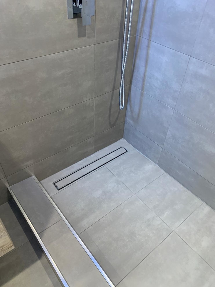 Inspiration för mellanstora vitt en-suite badrum, med luckor med upphöjd panel, bruna skåp, en öppen dusch, grå kakel, porslinskakel, grå väggar, betonggolv, grått golv och med dusch som är öppen