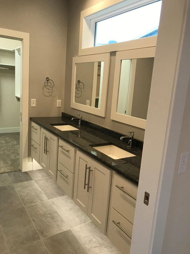 Imagen de cuarto de baño principal moderno de tamaño medio con armarios estilo shaker, puertas de armario blancas, suelo de baldosas de cerámica, lavabo bajoencimera, encimera de granito y suelo gris