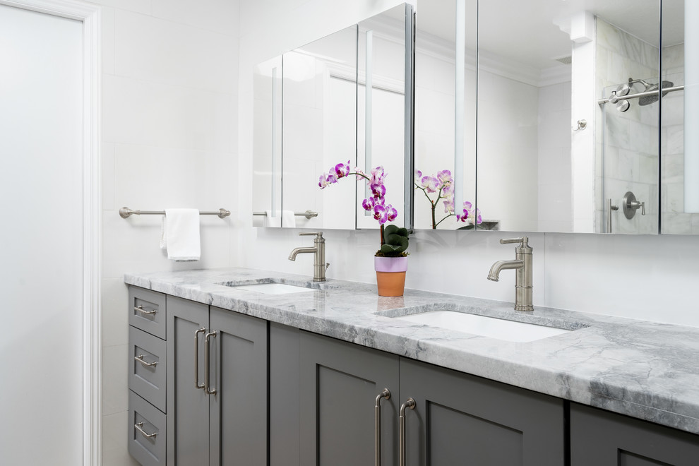 Inredning av ett modernt mellanstort grå grått badrum med dusch, med skåp i shakerstil, grå skåp, en dusch i en alkov, en toalettstol med hel cisternkåpa, grå väggar, ett undermonterad handfat, marmorbänkskiva, flerfärgat golv och dusch med skjutdörr