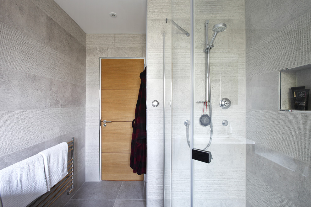 Exemple d'une salle de bain moderne de taille moyenne pour enfant avec un placard à porte plane, une baignoire posée et un mur gris.