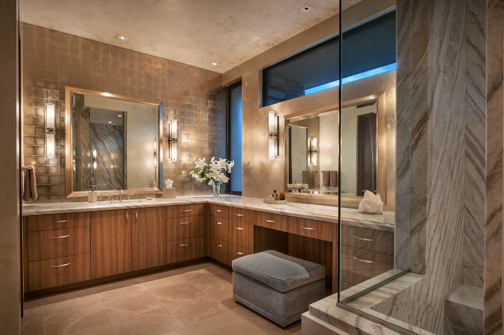 На фото: большая главная ванная комната в современном стиле с плоскими фасадами, светлыми деревянными фасадами, бежевой плиткой, стеклянной плиткой, бежевыми стенами, полом из известняка, врезной раковиной и столешницей из кварцита