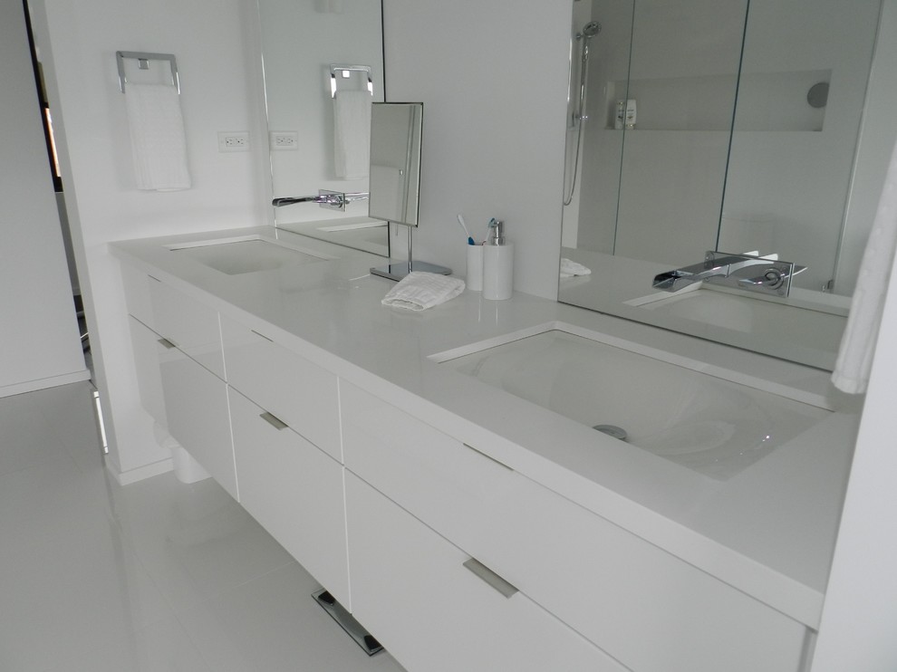 Large modern ensuite bathroom in Toronto with glass-front cabinets, white cabinets, a freestanding bath, a one-piece toilet, white tiles, porcelain tiles, white walls, porcelain flooring, a submerged sink and quartz worktops.