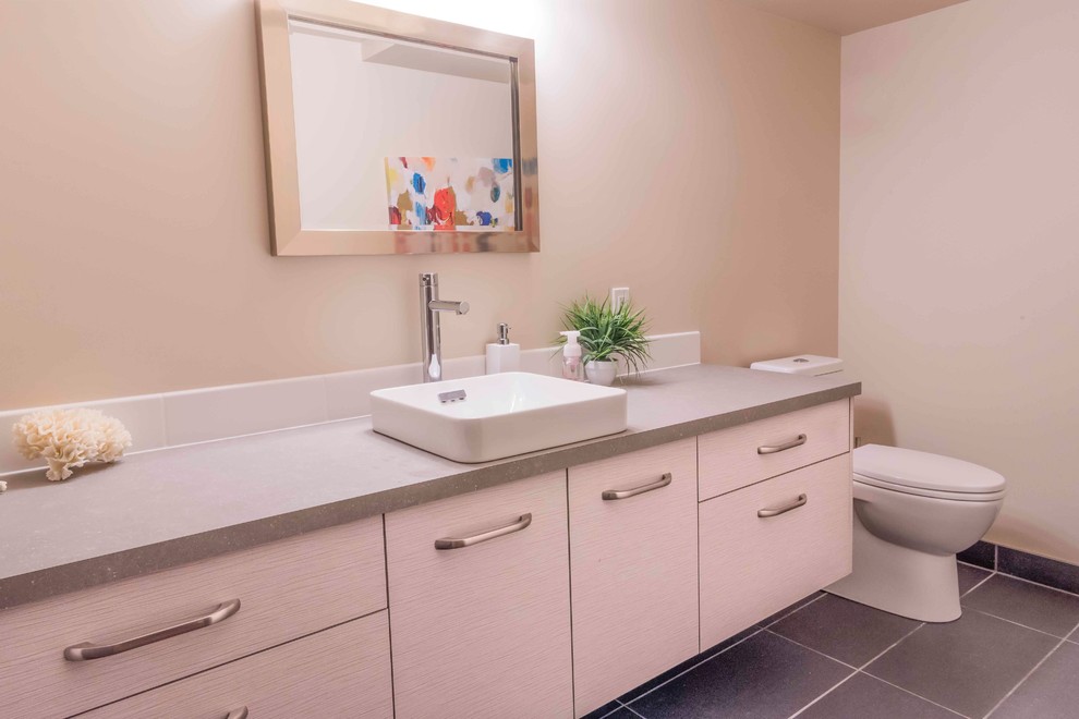 Modern inredning av ett mellanstort badrum med dusch, med släta luckor, skåp i slitet trä, beige kakel, beige väggar, klinkergolv i keramik, ett fristående handfat, bänkskiva i kvartsit och grått golv