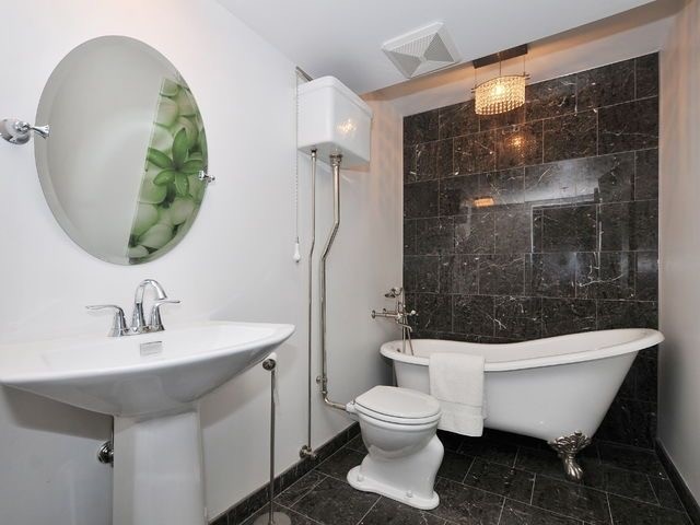 Exempel på ett litet eklektiskt badrum med dusch, med ett badkar med tassar, en toalettstol med separat cisternkåpa, svart kakel, stenkakel, vita väggar, marmorgolv och ett piedestal handfat