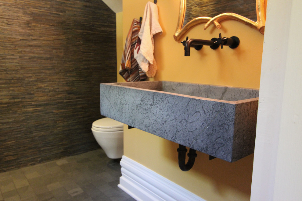 Réalisation d'une petite salle d'eau bohème avec un lavabo suspendu, un plan de toilette en stéatite, une douche ouverte, WC suspendus, un carrelage multicolore, un carrelage de pierre, un mur jaune et un sol en ardoise.