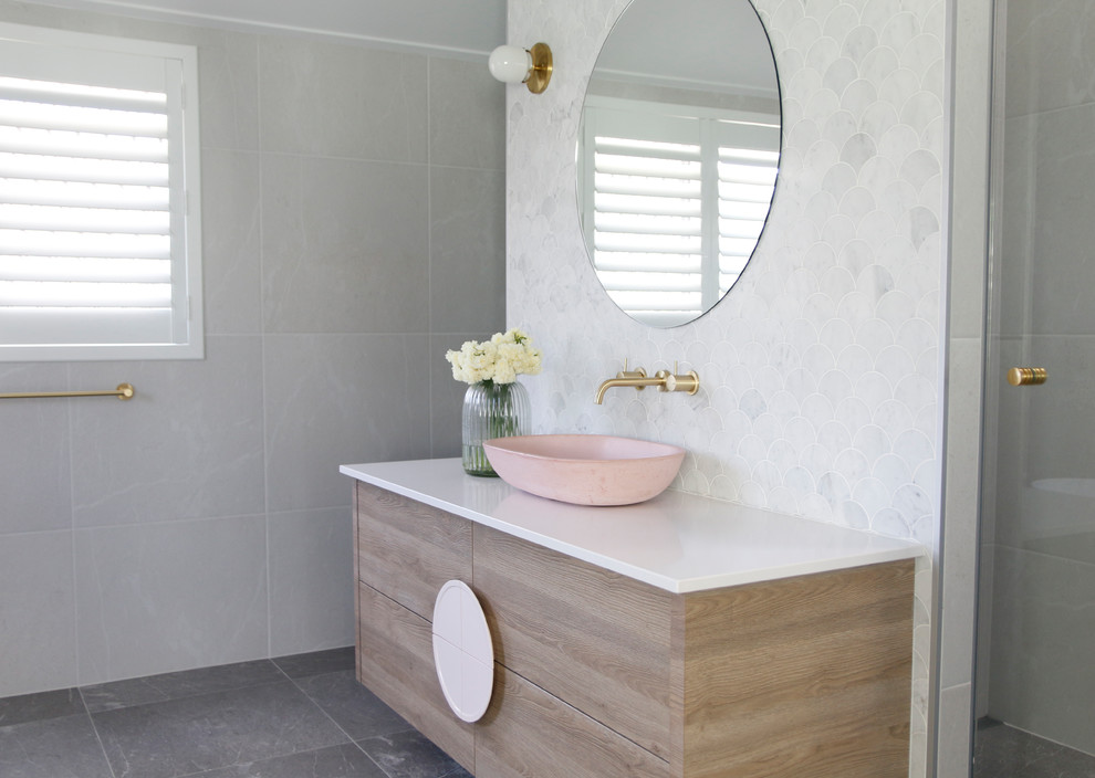 Design ideas for a large contemporary ensuite bathroom in Townsville with flat-panel cabinets, a built-in shower, grey tiles, ceramic tiles, ceramic flooring, engineered stone worktops, grey floors, a hinged door, white worktops, light wood cabinets and a vessel sink.