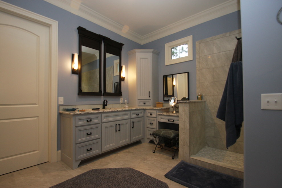 Bathroom - large craftsman master stone tile and beige tile beige floor and porcelain tile bathroom idea in Raleigh with recessed-panel cabinets, blue cabinets, granite countertops, a two-piece toilet, blue walls and an undermount sink