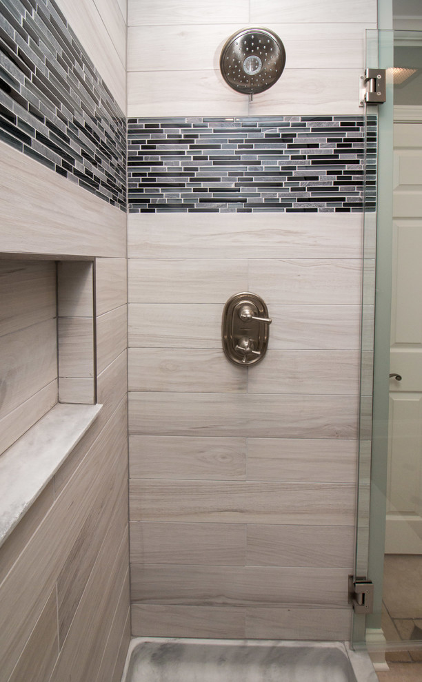 Foto på ett mellanstort funkis badrum med dusch, med en dusch i en alkov, en toalettstol med separat cisternkåpa, brun kakel, porslinskakel, grå väggar, klinkergolv i porslin, ett piedestal handfat, brunt golv och dusch med gångjärnsdörr