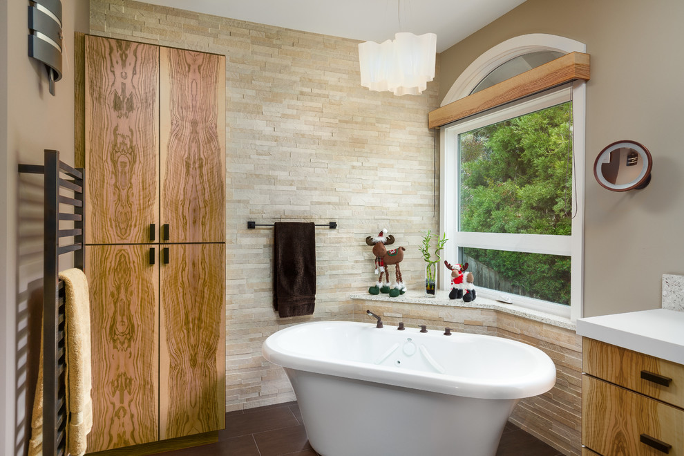Пример оригинального дизайна: большая главная ванная комната в стиле неоклассика (современная классика) с плоскими фасадами, светлыми деревянными фасадами, отдельно стоящей ванной, унитазом-моноблоком, керамогранитной плиткой, коричневыми стенами, полом из керамогранита, монолитной раковиной, столешницей из искусственного камня, душем в нише и бежевой плиткой
