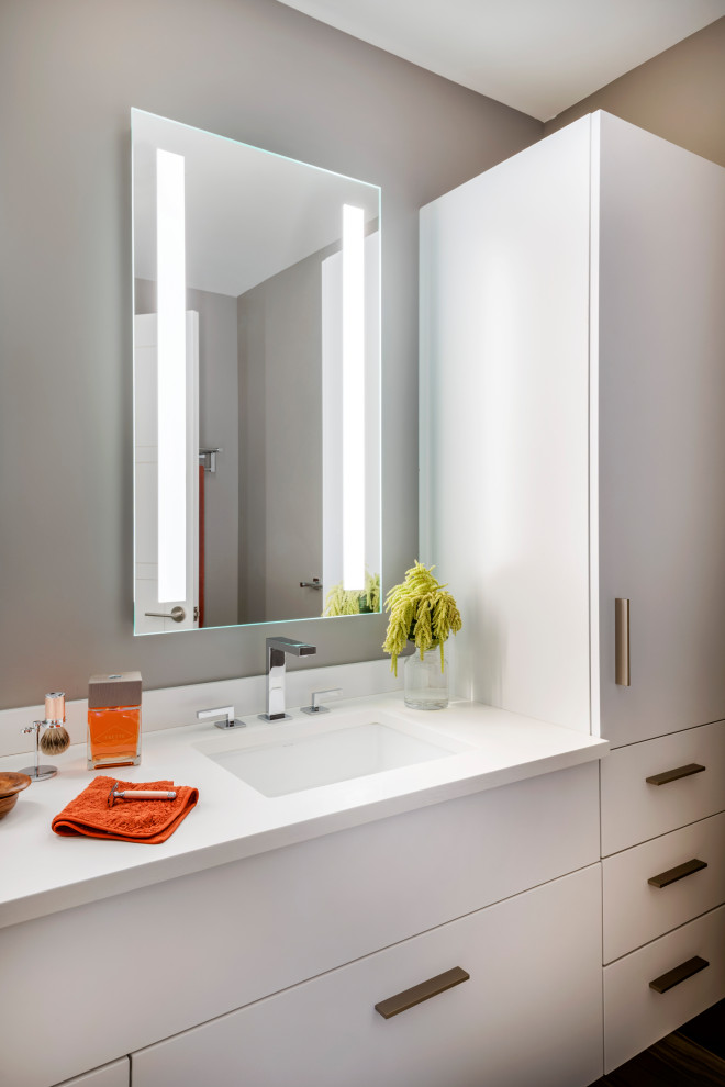 Inspiration for a small modern ensuite bathroom in Boston with flat-panel cabinets, grey cabinets, a walk-in shower, a wall mounted toilet, grey tiles, marble tiles, grey walls, porcelain flooring, a submerged sink, engineered stone worktops, grey floors, a hinged door, white worktops, double sinks and a floating vanity unit.