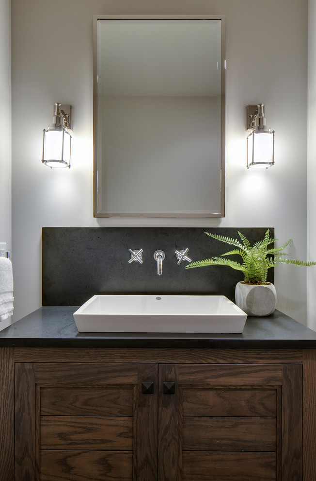 Idées déco pour une salle de bain éclectique en bois foncé de taille moyenne avec un placard avec porte à panneau encastré, un mur beige et un plan de toilette en granite.