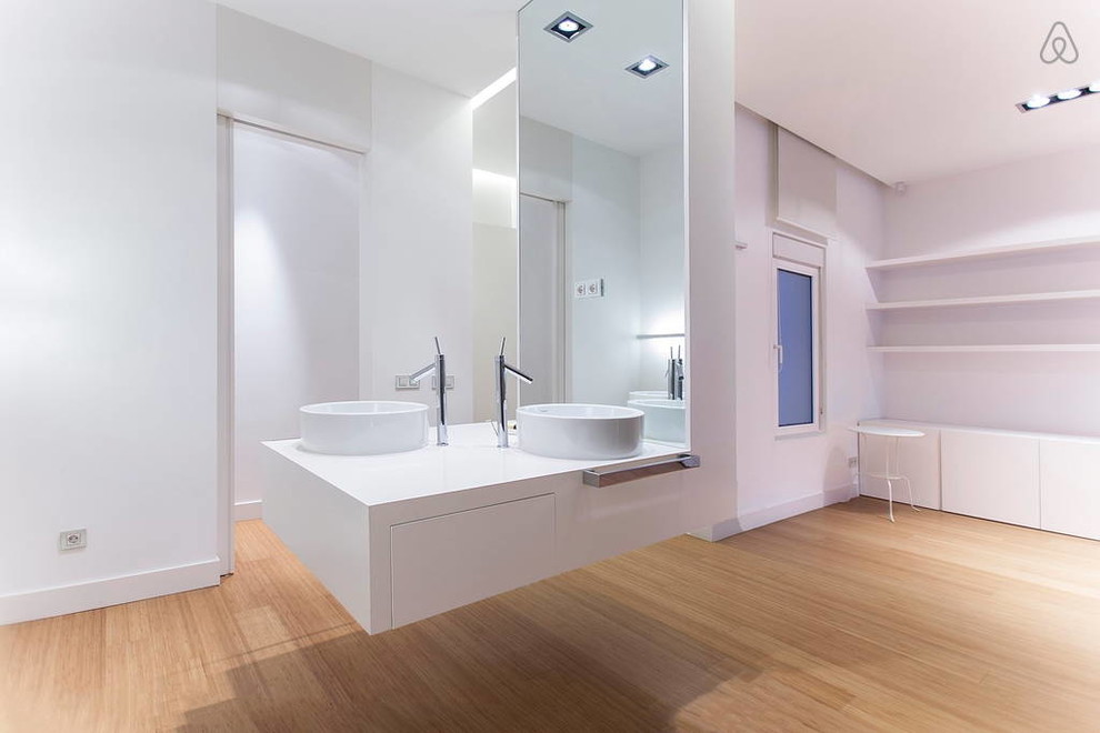 Идея дизайна: большая главная ванная комната в стиле модернизм с плоскими фасадами, белыми фасадами, белыми стенами, полом из бамбука, настольной раковиной и столешницей из искусственного кварца