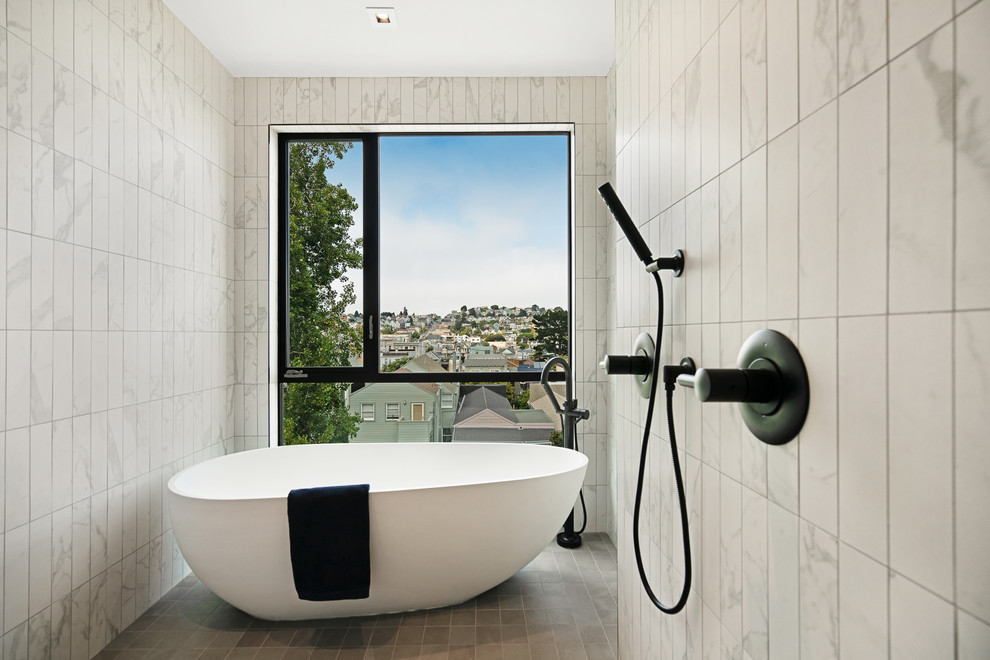 This is an example of a large contemporary bathroom in San Francisco with flat-panel cabinets, medium wood cabinets, a freestanding bath, white tiles, white walls, ceramic flooring and a hinged door.