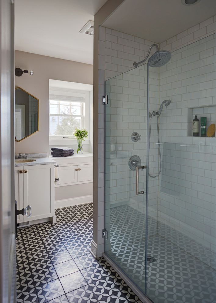 Inspiration for a mid-sized transitional 3/4 white tile and ceramic tile concrete floor alcove shower remodel in Chicago with shaker cabinets, white cabinets, a one-piece toilet, beige walls, a drop-in sink and marble countertops