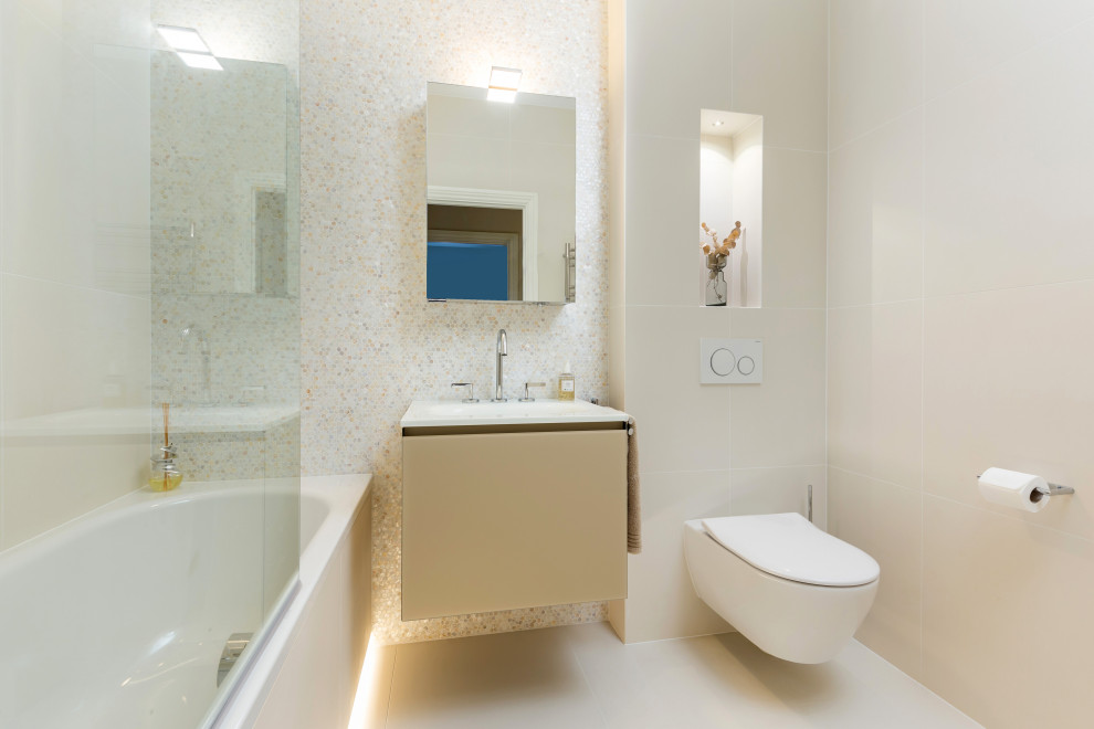 На фото: маленькая ванная комната в современном стиле с бежевыми фасадами, накладной ванной, душем над ванной, инсталляцией, бежевой плиткой, плиткой мозаикой, бежевыми стенами, полом из керамогранита, монолитной раковиной, стеклянной столешницей, бежевым полом, душем с распашными дверями, белой столешницей, нишей, тумбой под одну раковину, подвесной тумбой, многоуровневым потолком и плоскими фасадами для на участке и в саду
