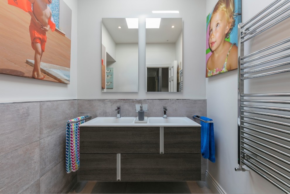 Foto di una piccola stanza da bagno design con ante lisce e ante in legno bruno