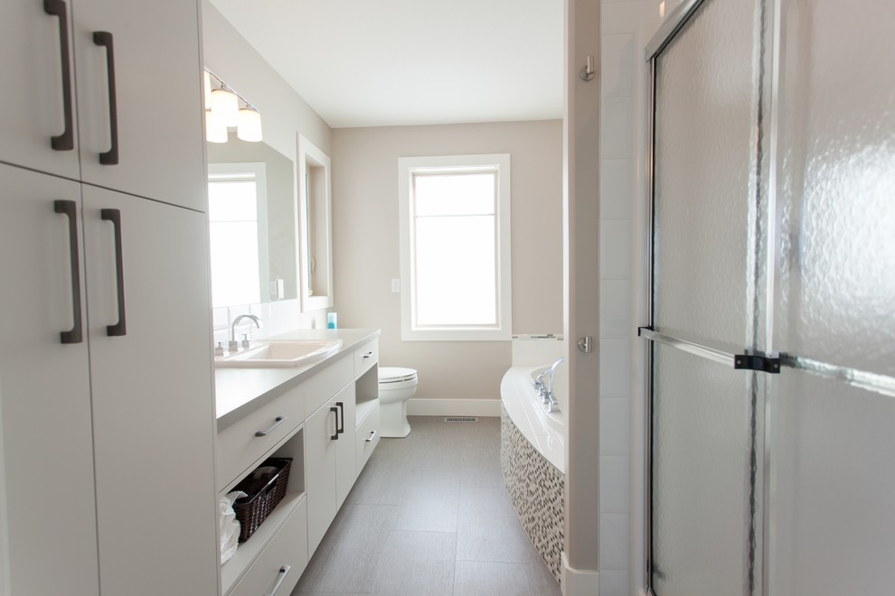 Ejemplo de cuarto de baño minimalista de tamaño medio con lavabo encastrado, armarios con paneles lisos, puertas de armario blancas, encimera de laminado, bañera empotrada, ducha empotrada, baldosas y/o azulejos blancos, baldosas y/o azulejos de cemento y paredes beige
