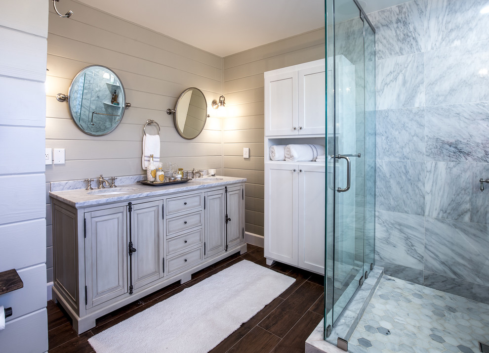 На фото: главная ванная комната в стиле неоклассика (современная классика) с серыми стенами, врезной раковиной и мраморной столешницей с