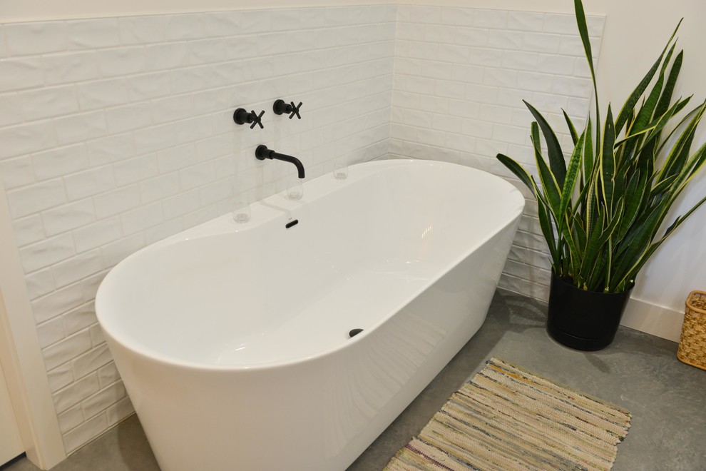 Cette image montre une salle de bain rustique avec une baignoire indépendante et des carreaux de béton.