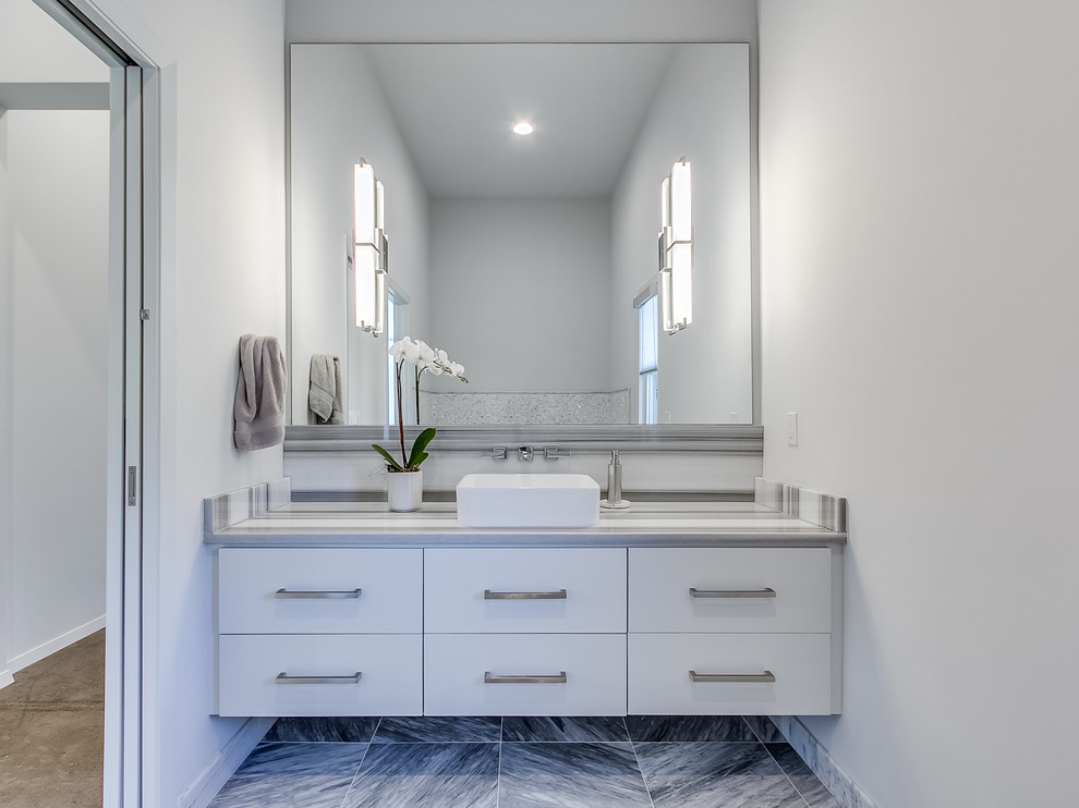 Diseño de cuarto de baño principal contemporáneo grande con armarios tipo mueble, puertas de armario grises, baldosas y/o azulejos grises, paredes grises, suelo de mármol, lavabo sobreencimera y encimera de mármol