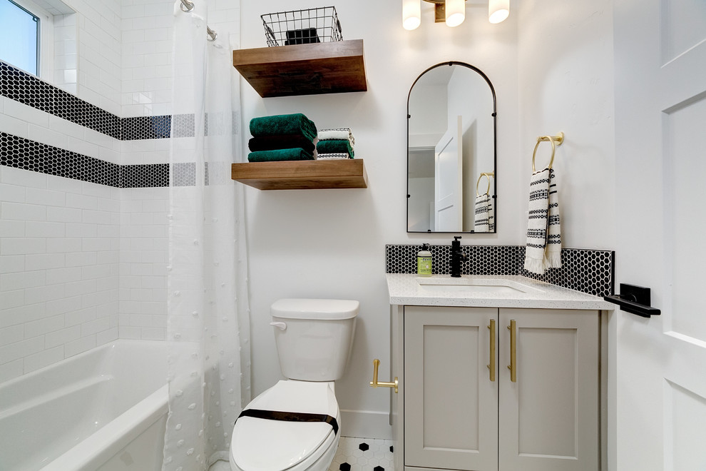 На фото: ванная комната среднего размера в стиле кантри с фасадами в стиле шейкер, серыми фасадами, ванной в нише, душем над ванной, унитазом-моноблоком, белой плиткой, плиткой кабанчик, белыми стенами, полом из керамической плитки, душевой кабиной, врезной раковиной, столешницей из искусственного камня, белым полом, шторкой для ванной и белой столешницей с