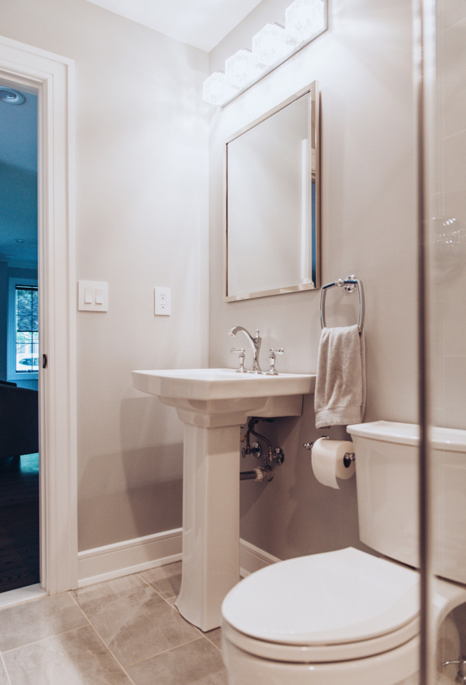 Inredning av ett modernt mellanstort badrum för barn, med en dusch i en alkov, keramikplattor, en toalettstol med separat cisternkåpa, grå väggar, klinkergolv i keramik, ett piedestal handfat, grått golv och dusch med gångjärnsdörr