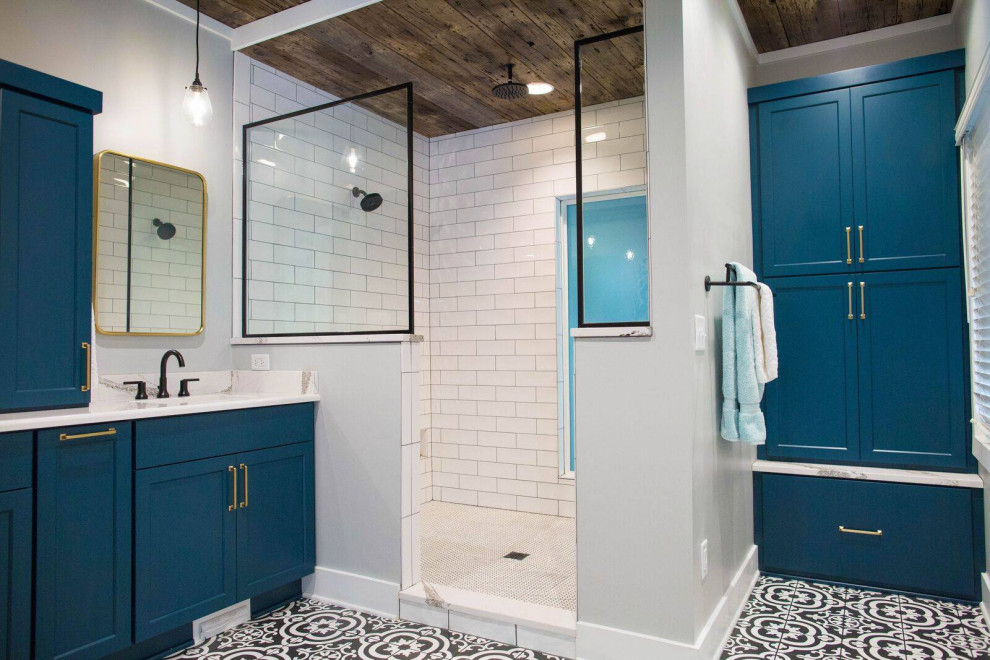 Источник вдохновения для домашнего уюта: большая главная ванная комната в стиле кантри с фасадами в стиле шейкер, синими фасадами, открытым душем, унитазом-моноблоком, белой плиткой, плиткой кабанчик, серыми стенами, полом из керамической плитки, врезной раковиной, столешницей из искусственного кварца, разноцветным полом, открытым душем и белой столешницей