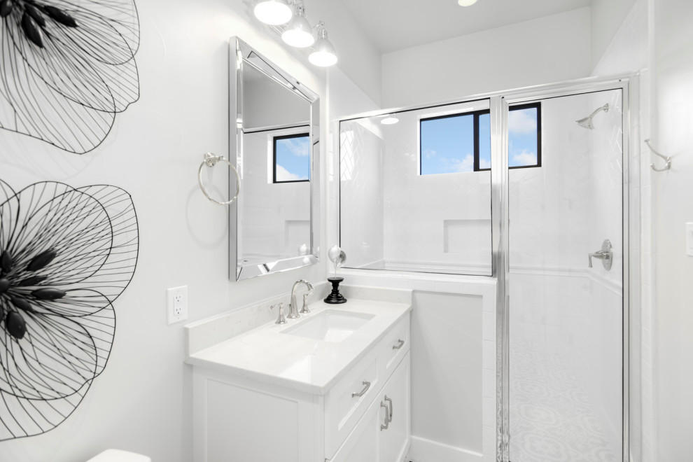 Exempel på ett mellanstort lantligt vit vitt badrum med dusch, med luckor med upphöjd panel, vita skåp, en dusch i en alkov, en toalettstol med hel cisternkåpa, vit kakel, vita väggar, klinkergolv i porslin, ett nedsänkt handfat, marmorbänkskiva, vitt golv och dusch med gångjärnsdörr