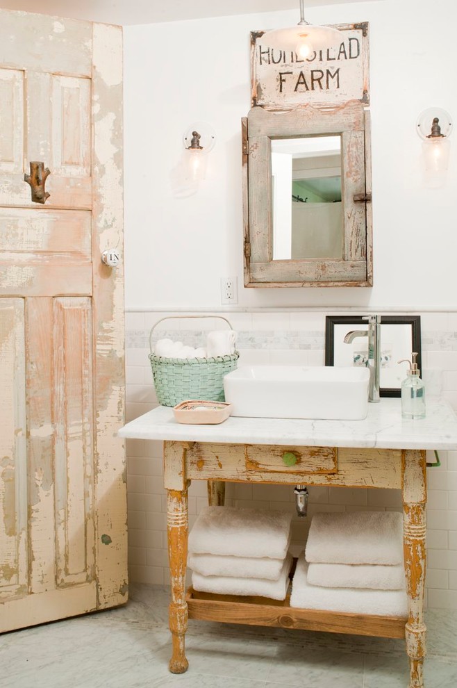 Foto de cuarto de baño romántico con puertas de armario con efecto envejecido, paredes blancas, lavabo sobreencimera y suelo blanco