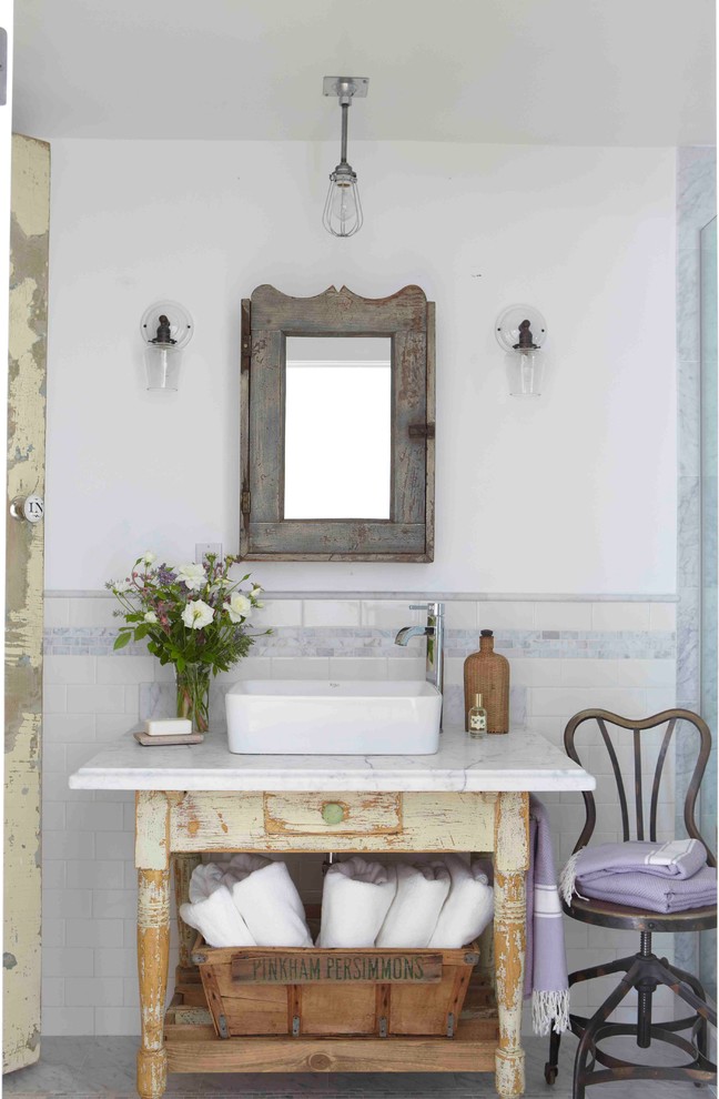 Imagen de cuarto de baño romántico con puertas de armario con efecto envejecido, paredes blancas y lavabo sobreencimera