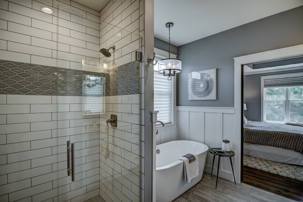 Imagen de cuarto de baño principal de estilo americano con bañera exenta, suelo de baldosas de porcelana y suelo gris