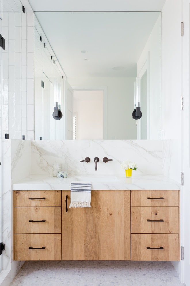 Foto de cuarto de baño principal costero con armarios con paneles lisos, puertas de armario de madera clara, ducha esquinera, encimera de mármol y ducha con puerta con bisagras