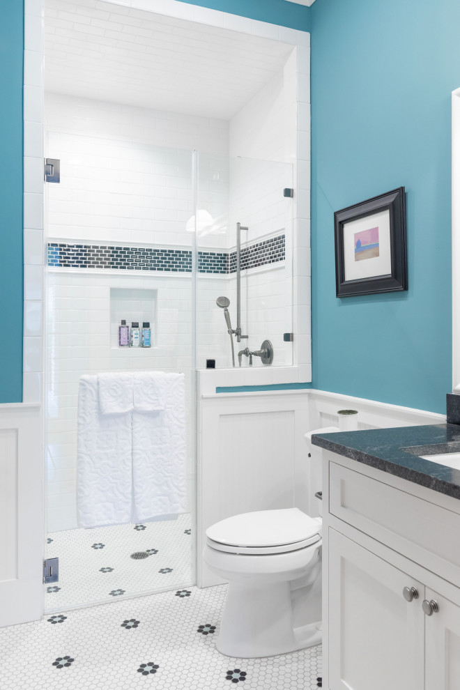 Foto på ett mellanstort lantligt svart badrum med dusch, med skåp i shakerstil, vita skåp, en dusch i en alkov, en toalettstol med separat cisternkåpa, blå väggar, cementgolv, ett undermonterad handfat, granitbänkskiva, vitt golv och dusch med gångjärnsdörr