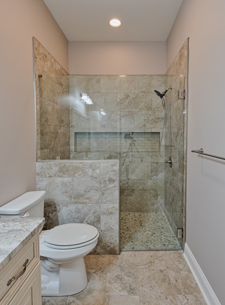 Alcove shower - large cottage beige tile and limestone tile limestone floor and beige floor alcove shower idea in Atlanta with shaker cabinets, dark wood cabinets, beige walls, an undermount sink, granite countertops, a hinged shower door, multicolored countertops and a built-in vanity