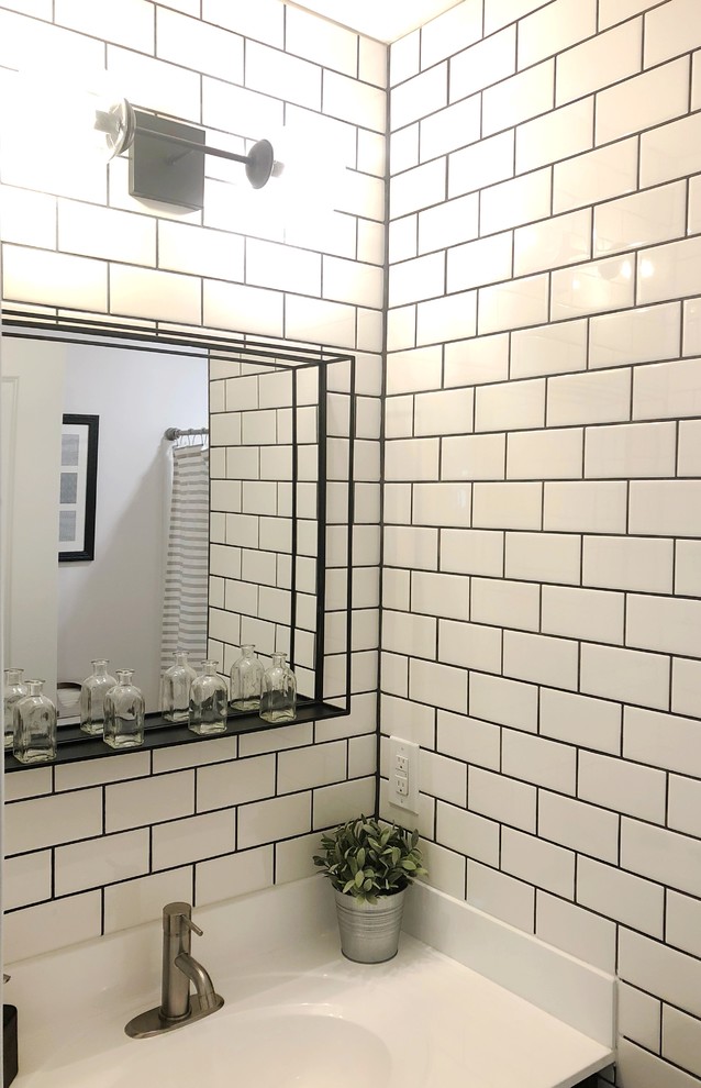 Réalisation d'une petite salle de bain champêtre avec un placard à porte shaker, des portes de placard noires, une baignoire posée, un combiné douche/baignoire, WC à poser, un carrelage blanc, un carrelage métro, un lavabo intégré, un plan de toilette en marbre, une cabine de douche avec un rideau et un plan de toilette blanc.