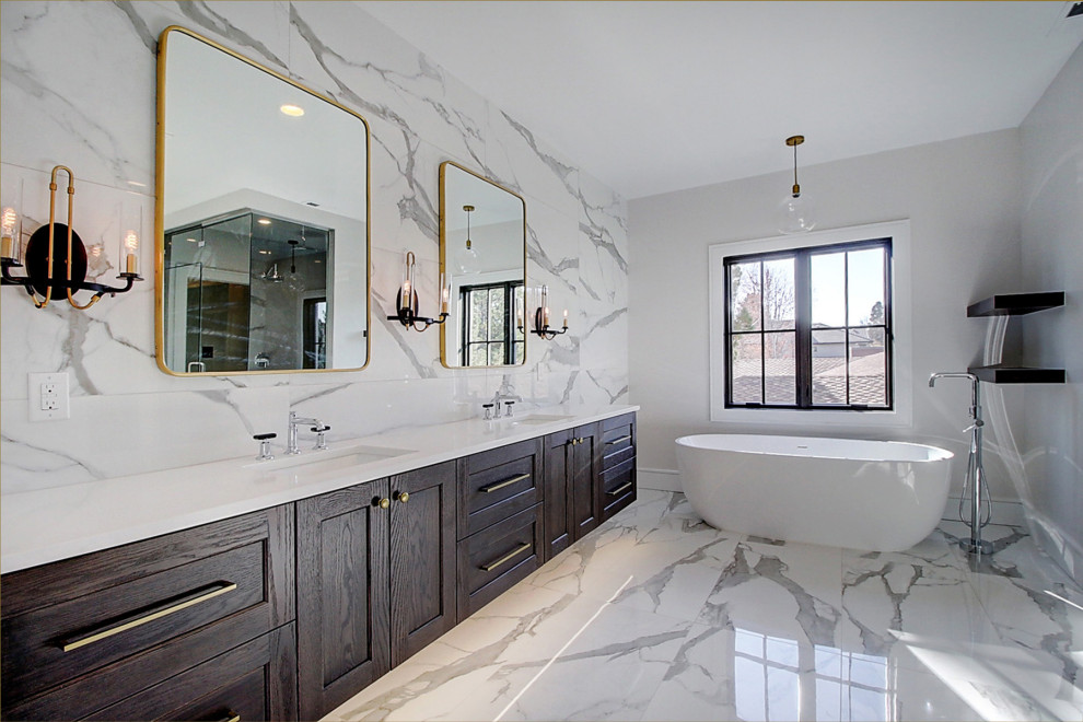 Klassisk inredning av ett stort vit vitt en-suite badrum, med luckor med infälld panel, skåp i mörkt trä, ett fristående badkar, en hörndusch, vit kakel, marmorkakel, vita väggar, marmorgolv, ett undermonterad handfat, bänkskiva i akrylsten, vitt golv och dusch med gångjärnsdörr