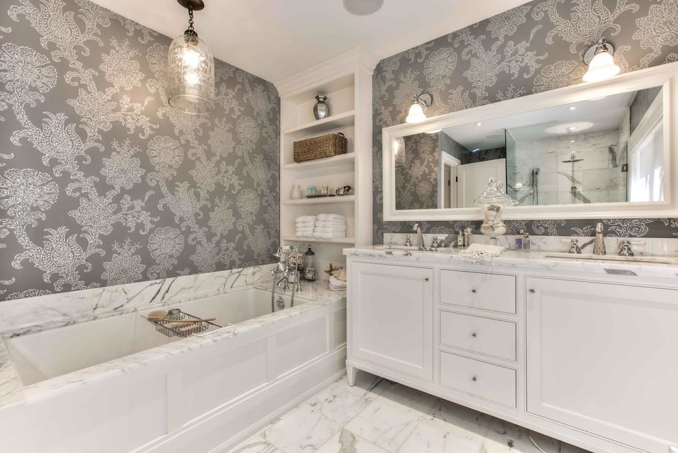 Photo of a medium sized classic grey and white ensuite bathroom in Toronto with recessed-panel cabinets, white cabinets, an alcove bath, a two-piece toilet, multi-coloured walls, marble flooring, a submerged sink, marble worktops and white floors.