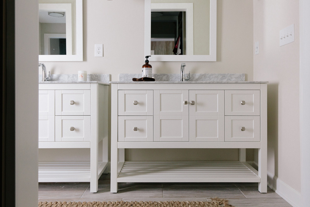 Klassisk inredning av ett stort en-suite badrum, med skåp i shakerstil, vita skåp, ett fristående badkar, en hörndusch, en toalettstol med separat cisternkåpa, grå kakel, keramikplattor, beige väggar, klinkergolv i keramik, ett undermonterad handfat och marmorbänkskiva