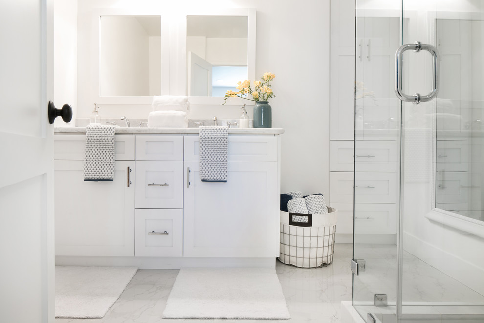 На фото: главная ванная комната среднего размера в стиле кантри с фасадами с утопленной филенкой, белыми фасадами, белой плиткой, белыми стенами и мраморной столешницей с
