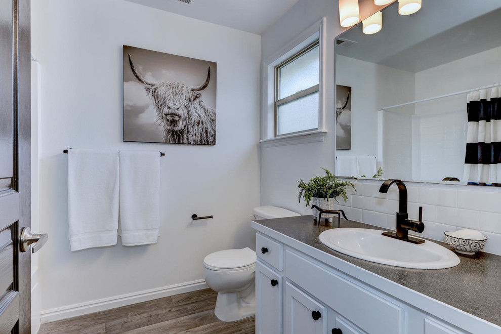 Idéer för mellanstora lantliga grått badrum, med skåp i shakerstil, vita skåp, en dusch i en alkov, vit kakel, keramikplattor, vita väggar, laminatgolv, laminatbänkskiva och dusch med skjutdörr