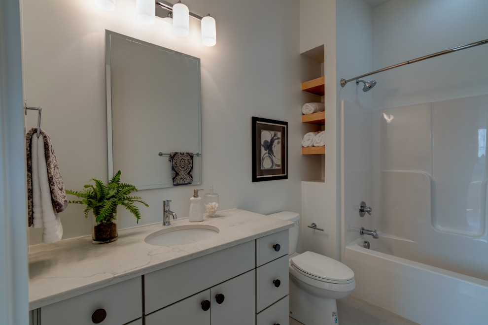 Country kids' ceramic tile, white floor and single-sink bathroom photo in Indianapolis with flat-panel cabinets, gray cabinets, a one-piece toilet, white walls, a drop-in sink, quartz countertops, white countertops, a niche and a freestanding vanity