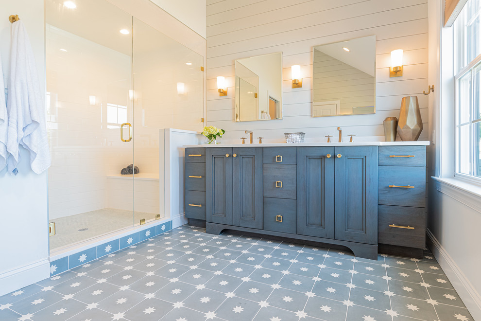 Источник вдохновения для домашнего уюта: большая главная ванная комната в стиле кантри с фасадами с утопленной филенкой, синими фасадами, душем в нише, унитазом-моноблоком, белой плиткой, керамогранитной плиткой, белыми стенами, полом из цементной плитки, врезной раковиной, столешницей из кварцита, синим полом, душем с распашными дверями и белой столешницей