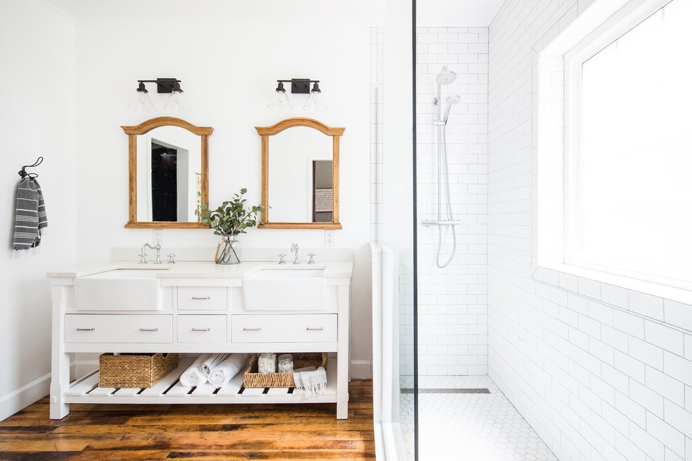 Источник вдохновения для домашнего уюта: ванная комната в стиле кантри с плоскими фасадами, белыми фасадами, угловым душем, белой плиткой, плиткой кабанчик, белыми стенами, паркетным полом среднего тона, врезной раковиной, коричневым полом, открытым душем, белой столешницей и зеркалом с подсветкой
