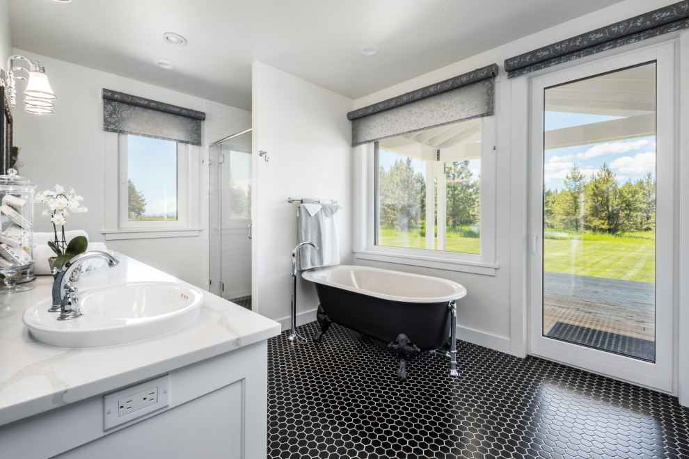 Photo of a bathroom in Boise with a claw-foot bath, a walk-in shower, a one-piece toilet, white walls, ceramic flooring, a built-in sink, black floors and an enclosed toilet.