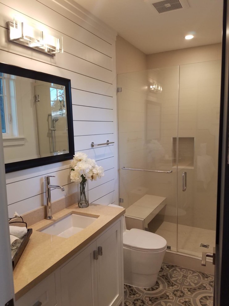 This is an example of a medium sized classic shower room bathroom in Los Angeles with recessed-panel cabinets, white cabinets, an alcove shower, a one-piece toilet, beige tiles, porcelain tiles, white walls, cement flooring, a submerged sink, engineered stone worktops, multi-coloured floors, a hinged door and beige worktops.