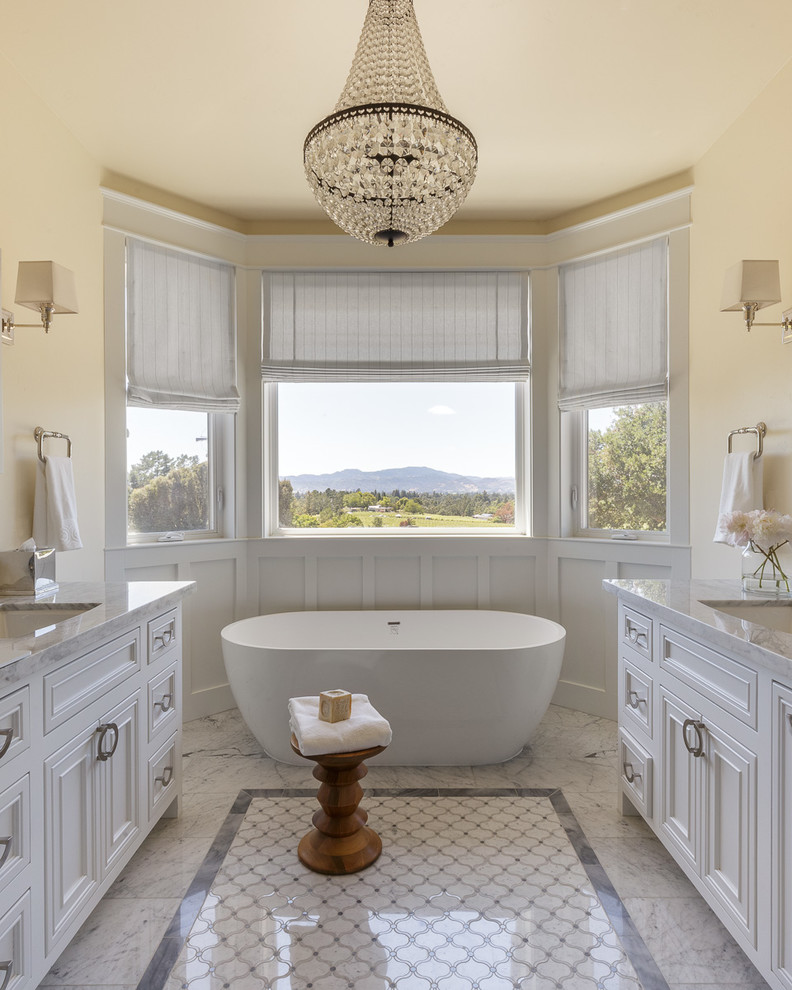 Idéer för att renovera ett stort lantligt en-suite badrum, med luckor med profilerade fronter, vita skåp, ett fristående badkar, stenkakel, gula väggar, mosaikgolv, ett undermonterad handfat, marmorbänkskiva, vitt golv, dusch med gångjärnsdörr och en dusch i en alkov