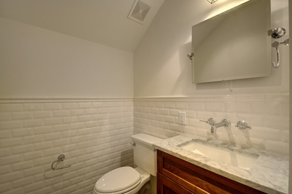 Immagine di una stanza da bagno con doccia country di medie dimensioni con ante in stile shaker, ante in legno bruno, WC a due pezzi, piastrelle bianche, piastrelle in ceramica, pareti bianche, lavabo sottopiano e top in marmo