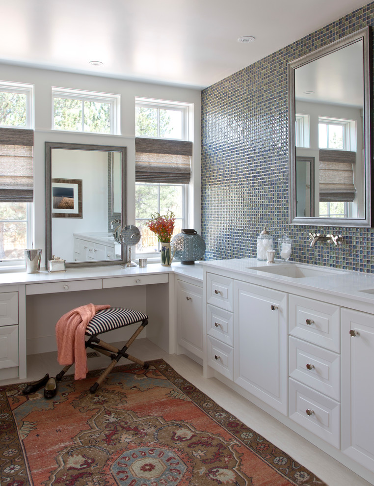 Photo of a traditional bathroom in Denver with recessed-panel cabinets, white cabinets, multi-coloured walls, a submerged sink and beige floors.